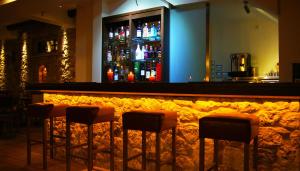 a bar with four stools in front of a counter at Olympios Zeus Hotel in Kato Zachlorou