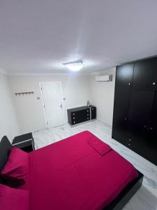 a bedroom with a pink bed and a tv at Narcis House in Thessaloniki +3 photos