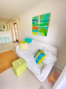 a living room with a white couch with colorful pillows at The Nook - Kerikeri in Kerikeri