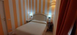 a small bedroom with a white bed and two lamps at Casa Tulliola in Moneglia