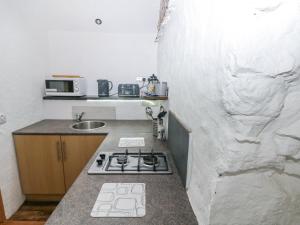 une petite cuisine avec une cuisinière et un évier dans l'établissement Anchor Light, à Pembroke