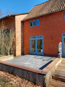 a brick house with a large patio in front of it at ALTE SCHEUNE Ferienwohnungen - Wohnung 1 in Suderburg