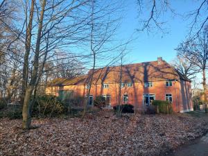a large brick building with trees in front of it at ALTE SCHEUNE Ferienwohnungen - Wohnung 1 in Suderburg