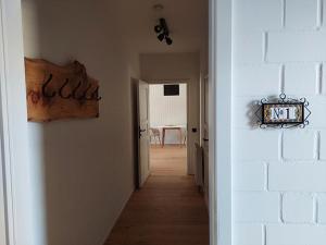 a hallway leading to a room with a white wall at ALTE SCHEUNE Ferienwohnungen - Wohnung 1 in Suderburg