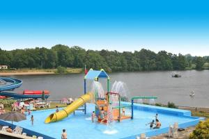 a pool with a water park with people playing in it at Casa 2234 op camping de Schatberg in Sevenum