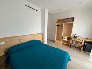 a bedroom with a blue bed and a desk at Hotel Valentino in Lavagna