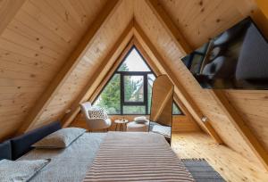 a bedroom in a attic with a large window at Mountain homes Durmitor 2 in Žabljak