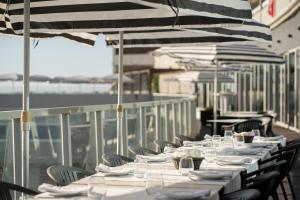 a row of tables and chairs with white plates and wine glasses at Arribas Sintra Hotel in Sintra