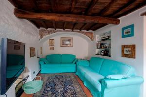 a living room with a blue couch and a tv at Casa al Castello in Lerici