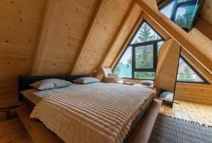 a bedroom with a large bed in a log cabin at Mountain homes Durmitor 2 in Žabljak +28 photos