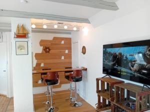 a living room with a bar and a flat screen tv at Bed and Boat in Præstø