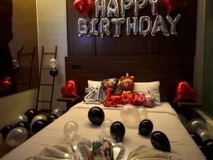 a bed with balloons and a sign that says happy birthday at The W Avenue in Bandung