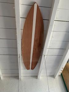 a wooden surfboard hanging on the wall of a room at Appartement 300m de la plage in Seignosse