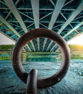 a large metal ring in the water under a bridge at Chez Tatiana in Lyon