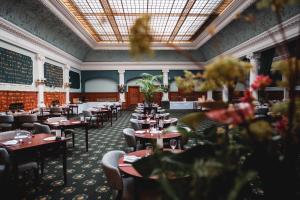 a dining room with tables and chairs and flowers at Old Swan Hotel in Harrogate