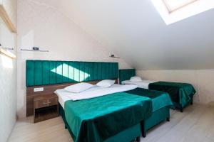 two beds in a room with green walls at Hotel Merty in Constanţa +49 photos