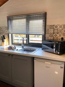 a kitchen with a sink and a microwave and a window at Otter 2 HuntersMoon- Warminster-Wiltshire-Bristol in Warminster
