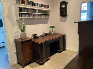 a desk in a room with a clock on the wall at Alte Post - Erdgeschoß in Gützkow