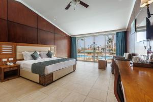 a hotel room with a bed and a desk and a bedroom at Sunrise Alora Aqua Park Resort in Hurghada +32 photos