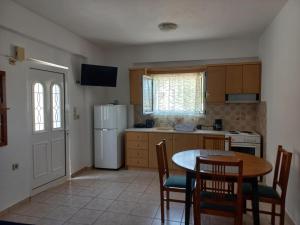 a kitchen with a table and a white refrigerator at Sophie's Sunny Spot 4 in Yéfira