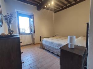 a bedroom with a bed and a window at Soggiorno nel Borgo in San Lorenzo a Merse