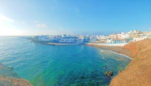 una vista aerea di una spiaggia con edifici bianchi di Sun&Sand Cotillo a Cotillo