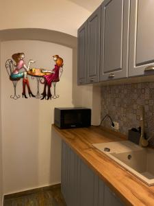 a kitchen with two women sitting at a table at Liberte Apartments in Oradea