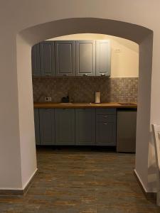 a kitchen with white cabinets and a tile floor at Liberte Apartments in Oradea +25 photos