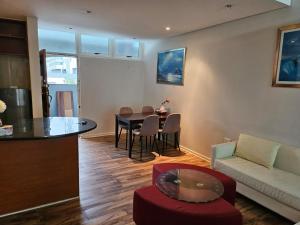una sala de estar con una mesa y un sofá en Lighthouse Apts Balcony apartment, en Durban