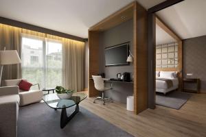 a living room with a couch and a bed and a desk at NH Collection San Sebastián Aranzazu in Donostia-San Sebastián