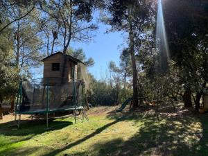 Un parque infantil con una jaula de bateo y una casa. en Villa Natura, en Saint-Jean-de-Cuculles