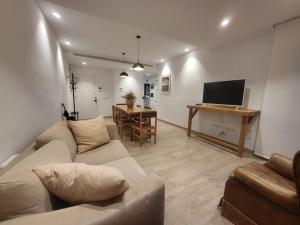 a living room with a couch and a table with a television at Piso céntrico de 3 habitaciones con terraza y vistas in Girona