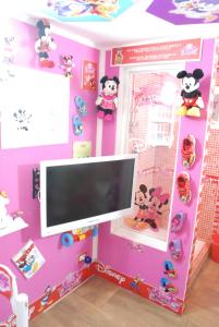 a tv in a room with a pink wall at DISNEY FAMILY Airport Catania City in CTA +17 photos