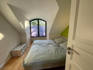 a attic bedroom with a bed and a window at Ferienwohnung im Grünen in Hagen im Bremischen