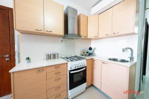 a kitchen with wooden cabinets and a stove top oven at A holiday Home in Gozo Right by the Sea in Marsalforn +14 photos