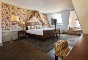 a bedroom with a bed and a chair at Hotel Detmolder Hof in Detmold