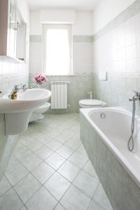 La salle de bains blanche est pourvue de 2 lavabos et d'une baignoire. dans l'établissement Leopardi Pineto Vacanza, à Pineto