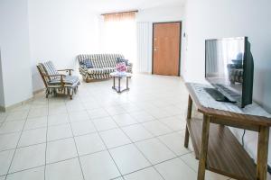 - un salon avec une télévision et un canapé dans l'établissement Leopardi Pineto Vacanza, à Pineto