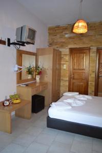 a bedroom with a bed and a desk and a tv at Penzion Blo in Panormos Skopelos