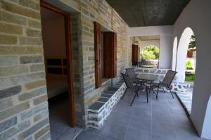 a patio with a table and chairs on a brick wall at Penzion Blo in Panormos Skopelos