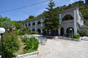 a building with a table and chairs in a courtyard at Penzion Blo in Panormos Skopelos