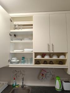 Una cocina con gabinetes blancos y un fregadero. en Thaly 5, en Debrecen