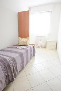 ピネートにあるLeopardi Pineto Vacanzaの白いタイルフロアのベッドルーム1室(ベッド1台付)
