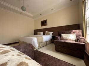 a bedroom with a bed and a couch and a chair at شقق منارا المدينة - Mnara Al-Madinah Apartments in Al Madinah
