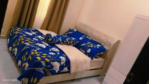 a bed with a blue comforter and pillows at Dee Riverside Homestay airport kota Bharu in Kota Bharu