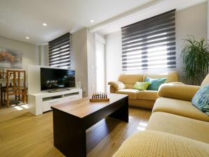 Una sala de estar con un sofá y un televisor. en Apartamento céntrico ideal para visitar Cuenca, en Cuenca