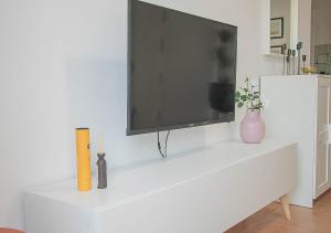 a flat screen tv sitting on top of a white cabinet at MojacarProperty Noalejo Beach Apartment in Mojácar