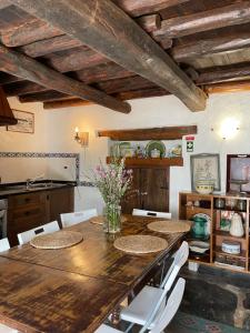 a dining room with a wooden table and white chairs at Casa do Olho d'Água in Portalegre