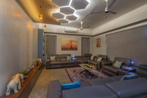 uma sala de estar com sofás e um cachorro sentado nela em SaffronStays Skylight em Alibag