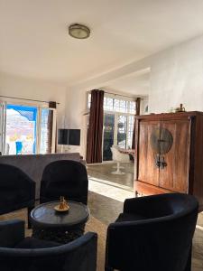 a living room with black chairs and a wooden cabinet at dar al bahar Taghazout -beachfront Apartment in Taghazout +11 photos